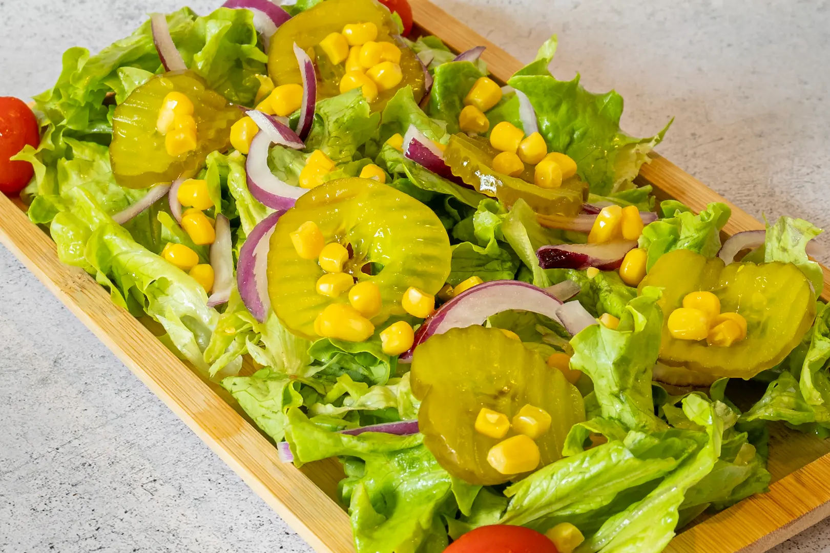 Photographie culinaire couleur d'une salade composée aux teintes vertes, rouges et jaunes vives.