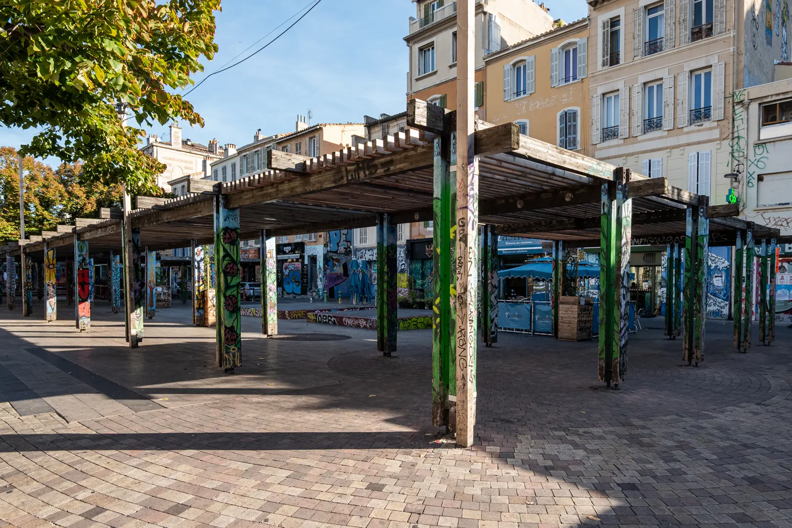 Pergolas graffées sur la place du Cours Julien à Marseille, symbole du quartier des créateurs et du street-art.