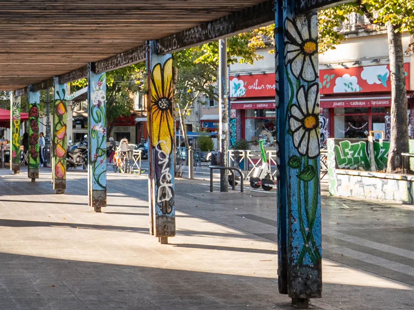 Colonnes décorées de fleurs peintes au Cours Julien à Marseille, quartier des créateurs et haut lieu du street-art.