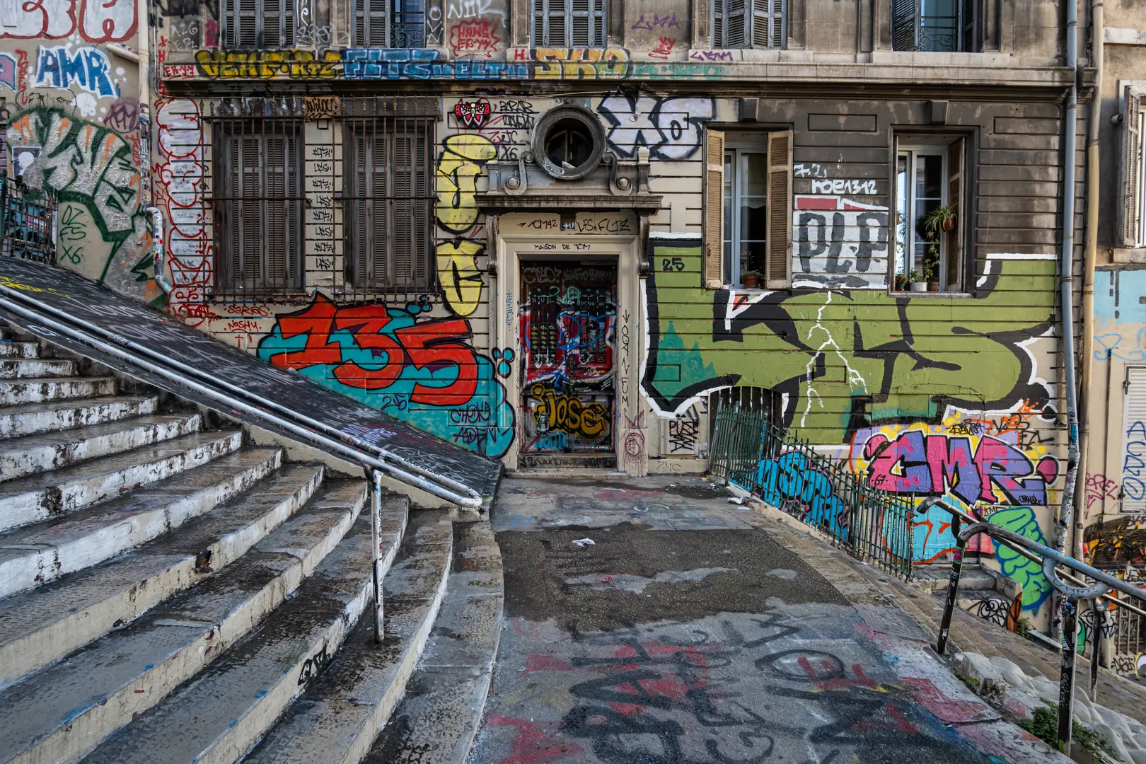 Escalier graffé et façade taguée au Cours Julien à Marseille, quartier des créateurs et haut lieu du street-art urbain.