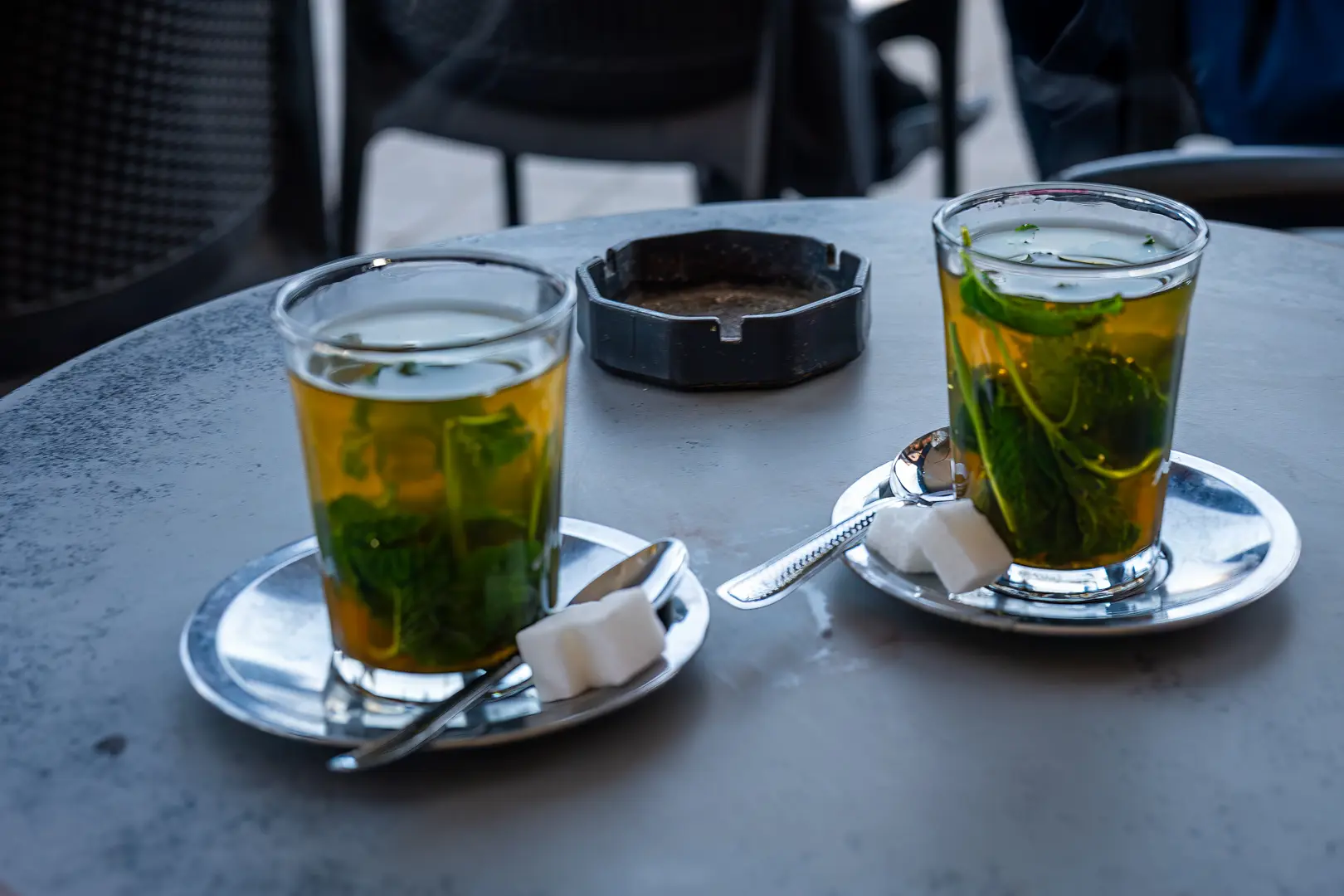 erre de thé à la menthe sur une table de café marocain Mint tea glass on a Moroccan café table